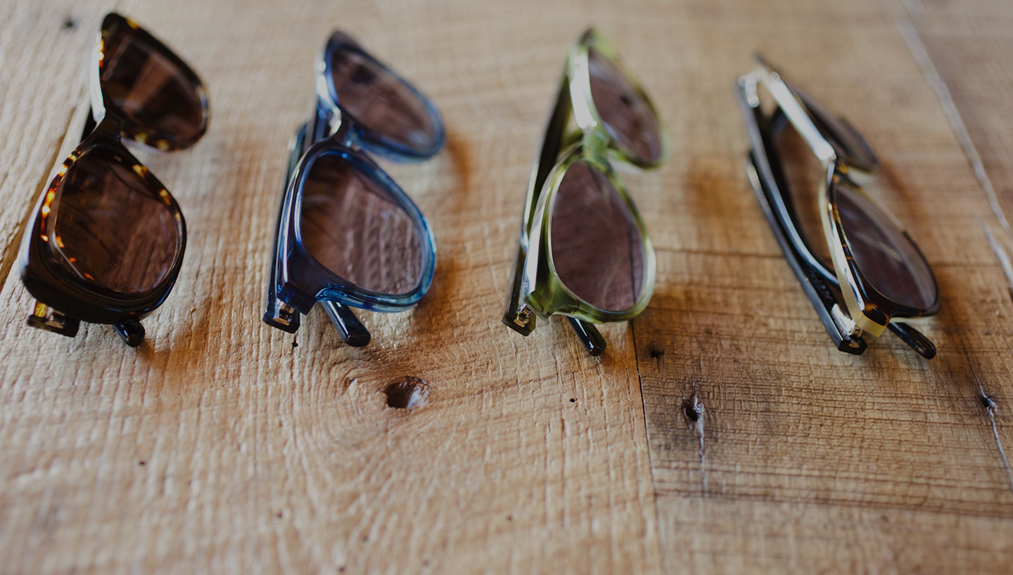 Four pairs of glasses lined up on wood table
