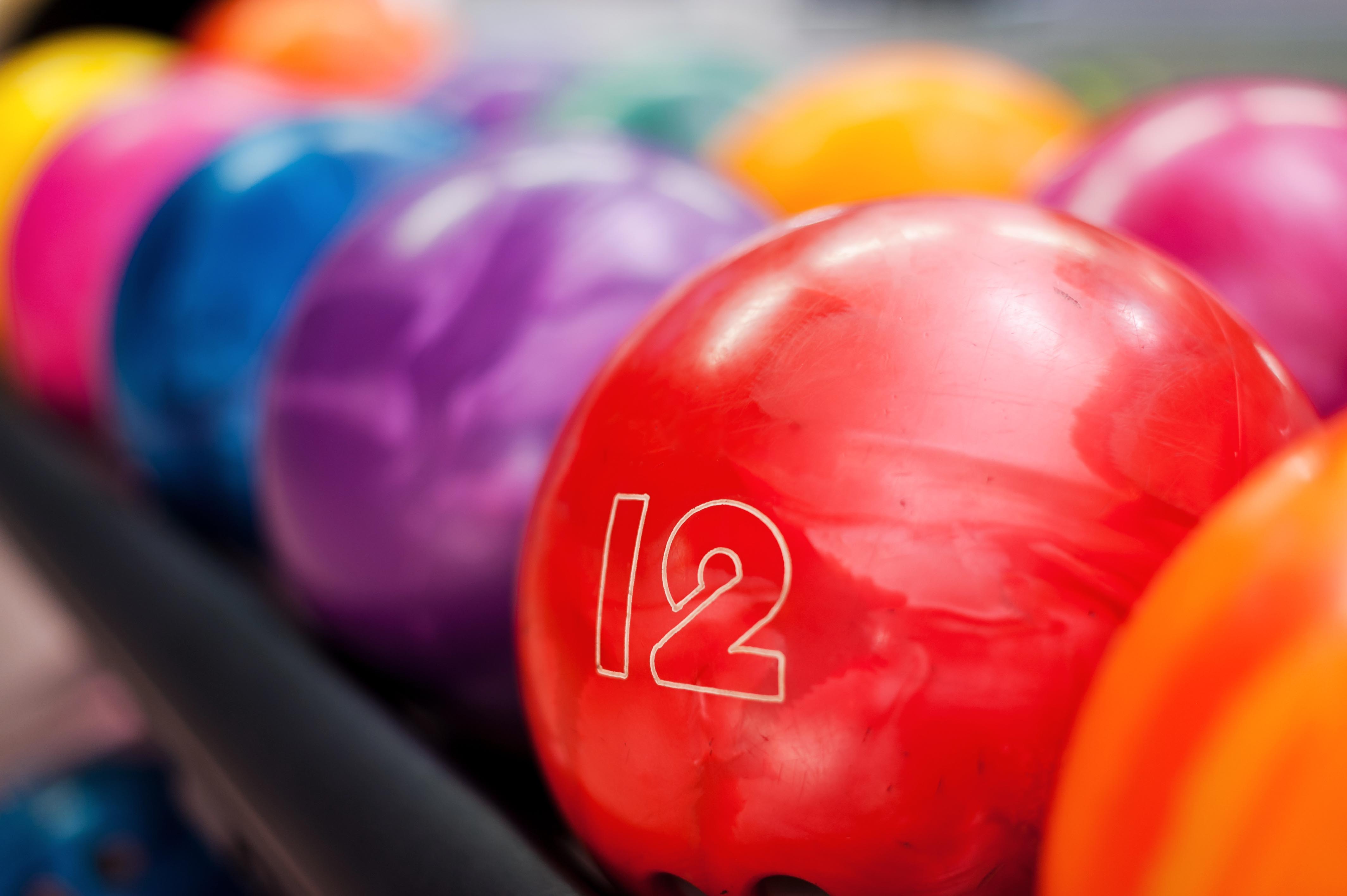 Bowling balls lined up on rack