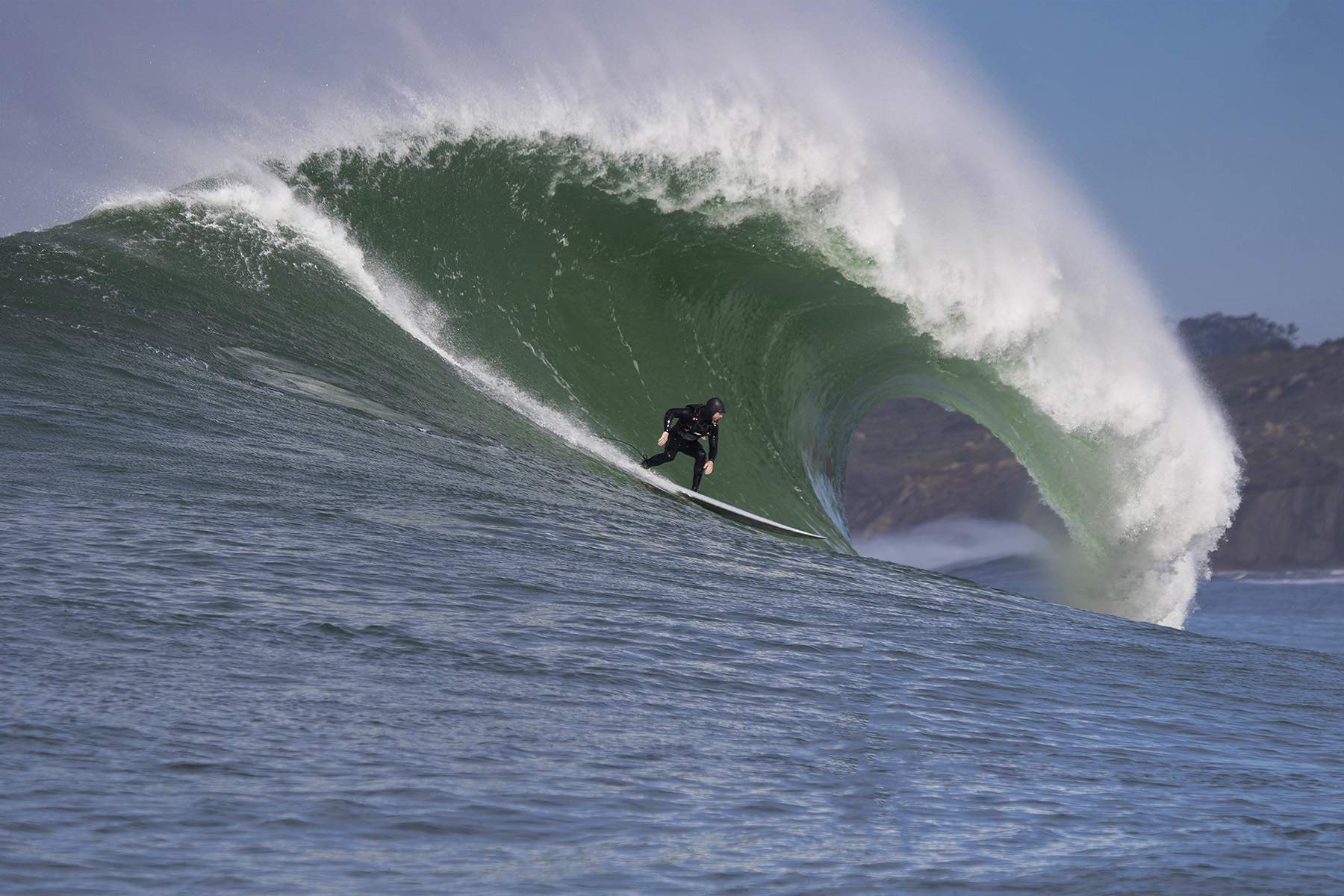 Side view of person surfing inside large wave