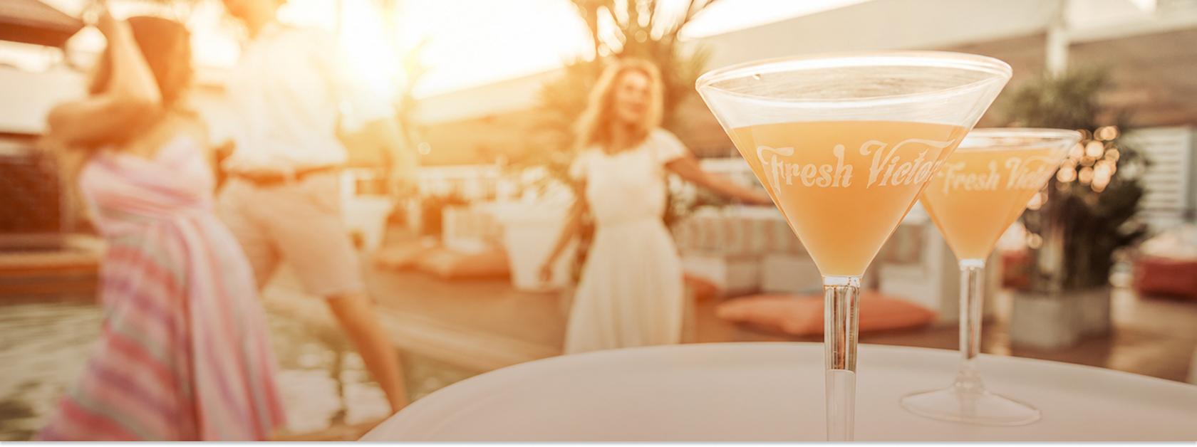 cocktail on a table with people dancing in the background